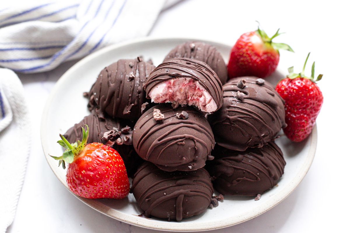 Strawberry frozen yogurt in glass bowl, ice cream balls, container